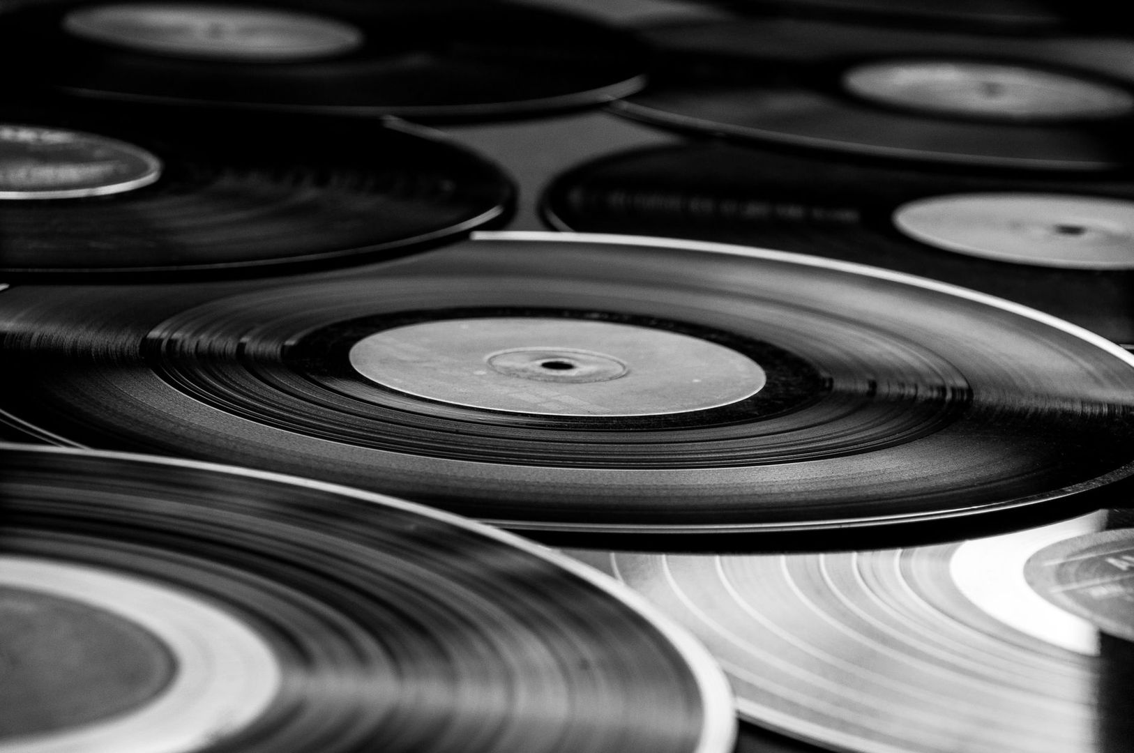 Black-and-white close-up of overlapping grooved phonograph records